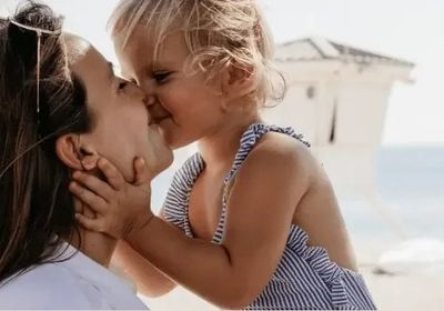A mother and her small daughter touching foreheads, close together