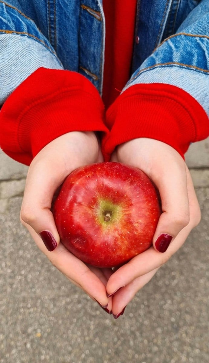 teen holding apple, engaging in healthy habits after counseling in Frisco, Texas