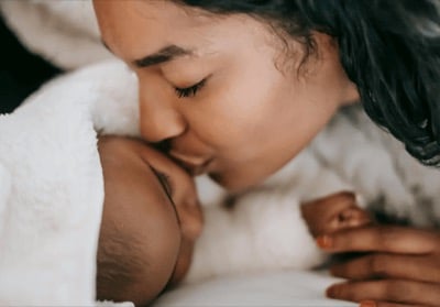 A mother holding her newborn close