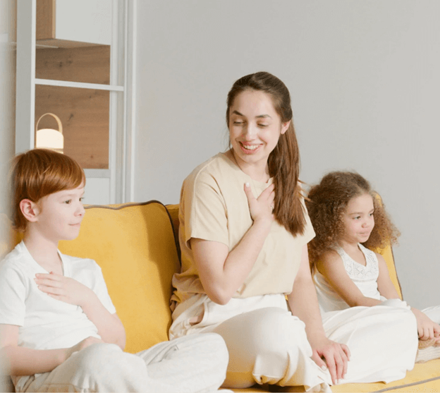 A parent sitting on a sofa with two young children