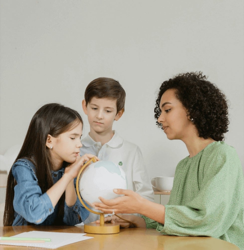 A teacher sitting at a desk with her head in her hands